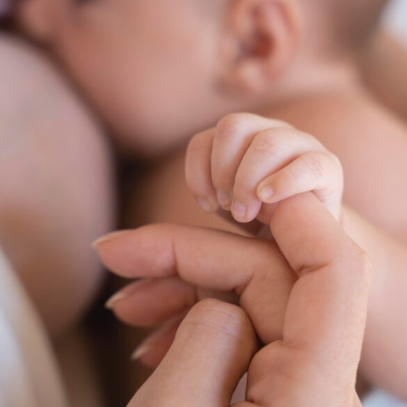 Bebé agarrando el dedo de su madre durante la lactancia. Asesora asesoría ayuda crianza respetuosa Galicia